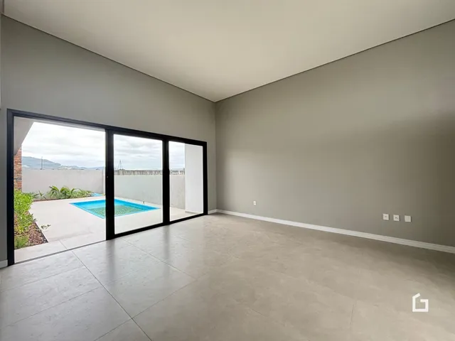Ambiente interno com porta de vidro que dá acesso a uma área externa com piscina.