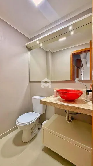 Foto de um banheiro com vaso sanitário e bancada.