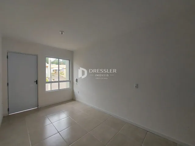 Vista interna de um cômodo com piso de cerâmica e porta branca.