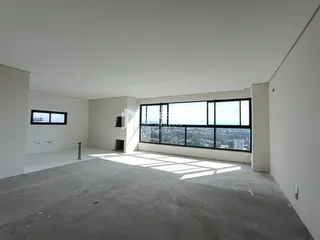 Espaço interno de um imóvel com grande janela de vista para a cidade.