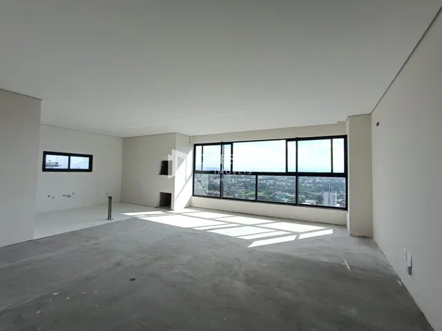 Espaço interno de um imóvel com grande janela de vista para a cidade.