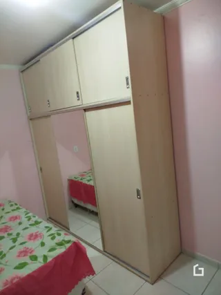 Quarto com armários embutidos e cama visível
