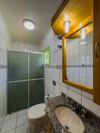 Foto de um banheiro com revestimento cerâmico branco.