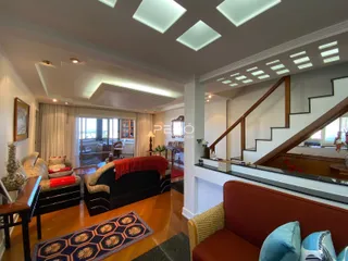 Sala de estar com piso de madeira e acesso a uma vista externa.