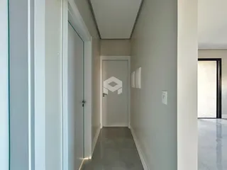 Hall de entrada com paredes brancas e piso cinza claro.