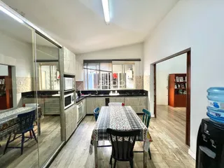 Vista interna de uma sala de jantar com reflexo de uma cozinha em Lajeado.