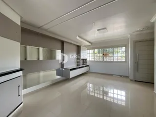 Ambiente interno de uma sala de estar com piso de cerâmica e armários de cozinha modernos.