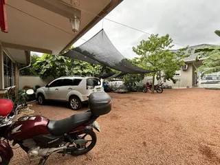 Vista da fachada de uma residência em Lajeado, Brasil, com veículos estacionados na frente.