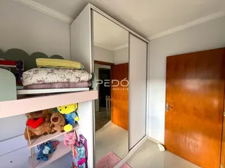Quarto com cama e armário branco em um imóvel no Brasil.