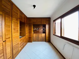 Interior com armários de madeira e piso de cerâmica.