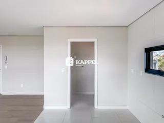 Hall de entrada interno com paredes brancas e porta de acesso.