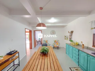Uma sala de jantar ampla com mesa de madeira e armários azuis no interior da propriedade.