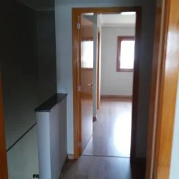 Vista interna de um corredor com acabamento em madeira em uma propriedade em Lajeado.
