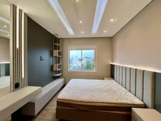 Quarto moderno com vista para a janela e a paisagem urbana.