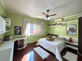 Quarto com decoração verde e piso de madeira em uma residência no Brasil.