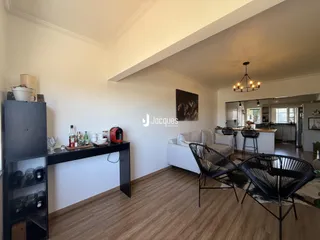 Sala de estar com piso de madeira e móveis.