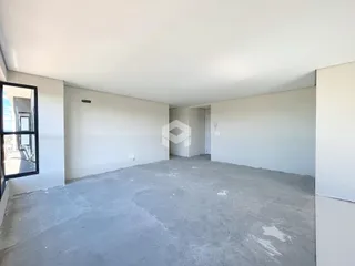 Foto de um espaço interno vazio com paredes brancas e piso de concreto.