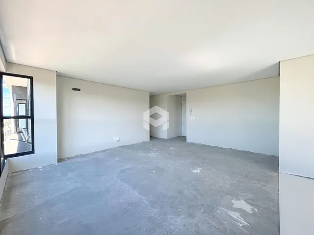 Foto de um espaço interno vazio com paredes brancas e piso de concreto.