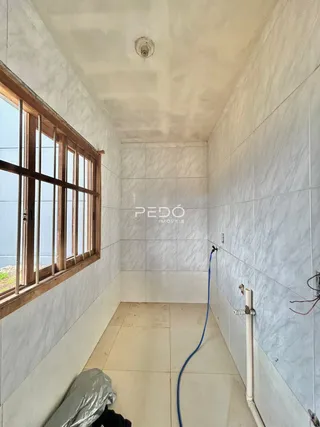 A parede interna de uma residência em Lajeado, Brasil, mostra uma janela e um piso de cerâmica.