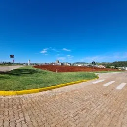 Vista externa de uma área gramada com pavimento.