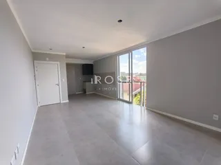 Vista ampla de uma sala de estar com piso de cerâmica e portas de vidro.