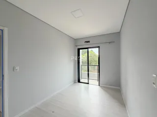 Hall de entrada com piso claro e porta de vidro.