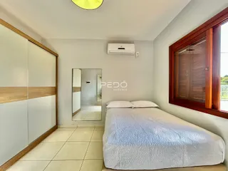 Quarto com armário de madeira e janela.