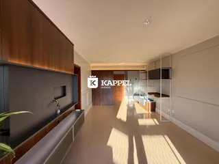 Uma sala de estar com painel de madeira e piso claro é visível na área interna.