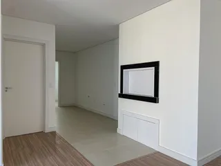 Foto de um corredor interno com paredes brancas e piso de madeira.