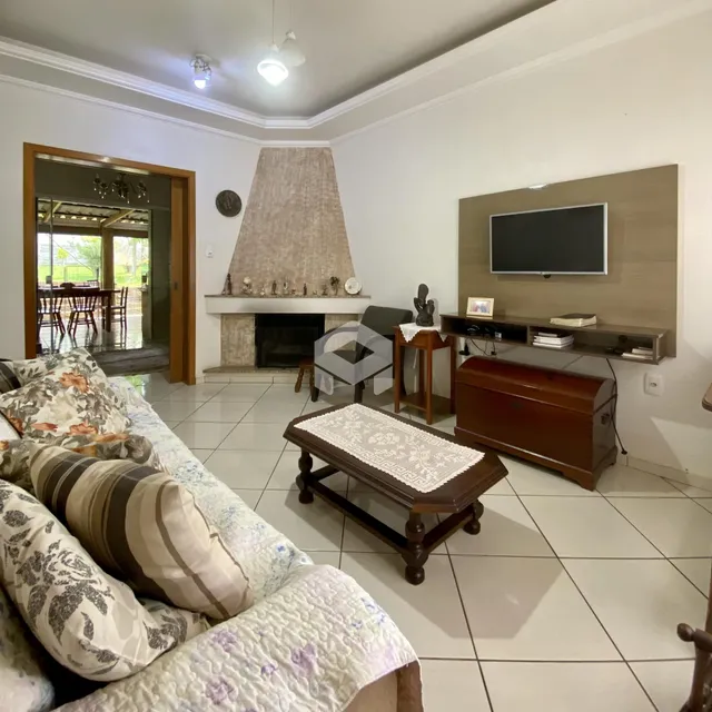 Sala de estar com lareira e área de jantar visível na abertura.