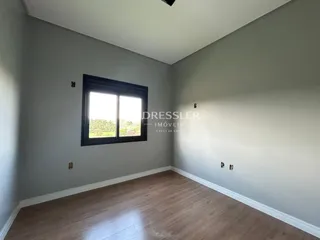 Sala de estar com piso de madeira e janela em um imóvel no Brasil.