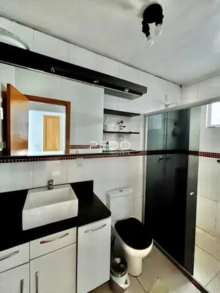 Foto de um banheiro moderno com pia e vaso sanitário.