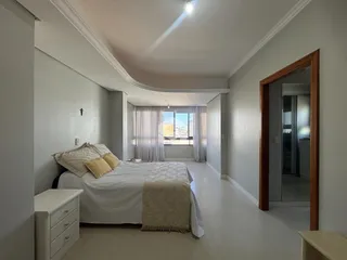 Quarto com cama e janela bem iluminada.