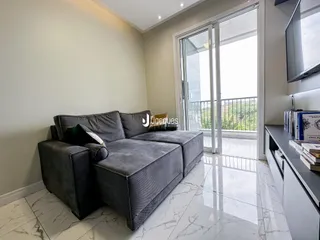 Sala de estar com sofá e portas de vidro que dão para a vista.