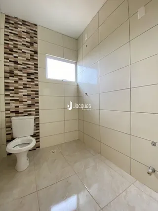 Foto de um banheiro com revestimento de azulejos brancos.