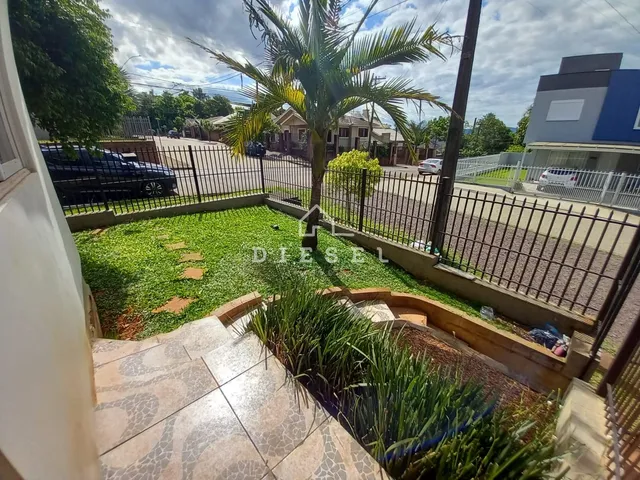 Vista de um jardim com grama e vegetação em uma área externa.