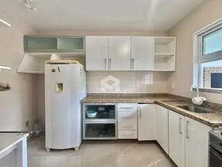 Foto de uma cozinha com armários brancos e bancada de granito.