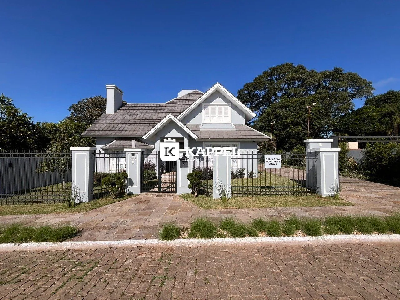 Fachada de uma casa residencial em Lajeado, Brasil, com cerca e paisagismo.