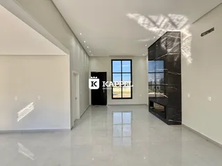 Sala de estar moderna com piso claro e grande janela.