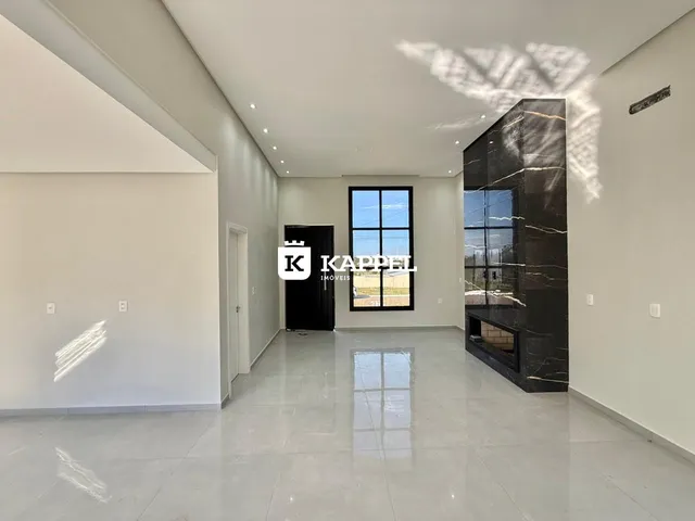 Sala de estar moderna com piso claro e grande janela.