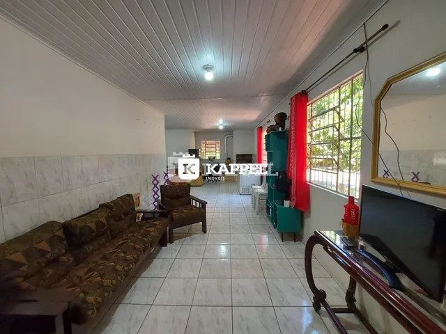 Uma sala de estar longa com sofá e uma grande janela que oferece vista para o exterior.
