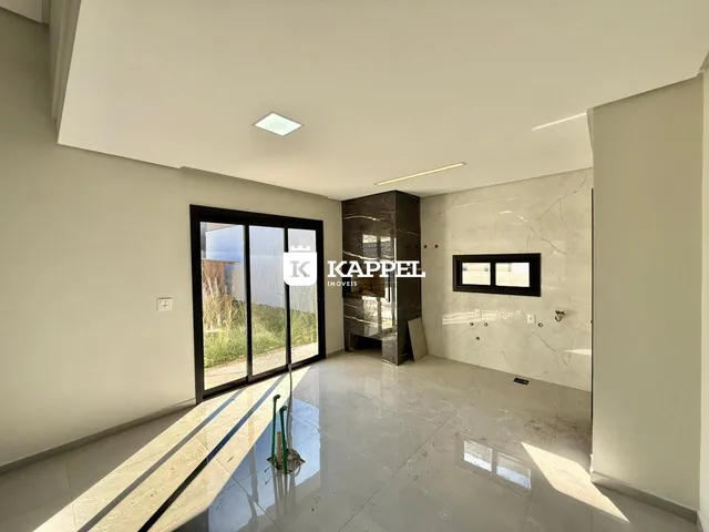 Sala de estar com piso de cerâmica e porta de vidro que dá para o jardim.