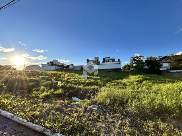 Vista externa de uma propriedade com gramado em primeiro plano sob luz solar intensa.