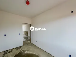 Hall de entrada com paredes brancas e piso de concreto.