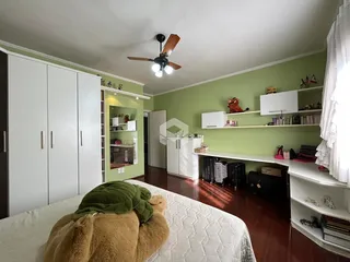 Quarto com armários brancos e piso de madeira em uma residência.