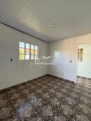 Foto do interior de um ambiente com piso de ladrilhos escuros.