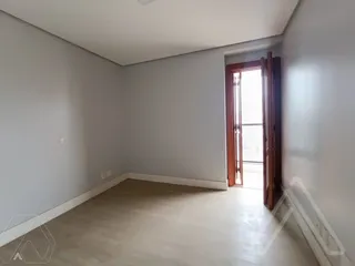 Uma foto de um cômodo interno com paredes claras e piso neutro.