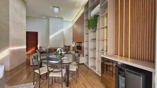 Sala de estar com mesa de jantar e estantes de madeira.