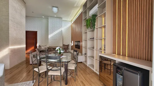 Sala de estar com mesa de jantar e estantes de madeira.