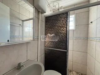 Foto de um ambiente interno com revestimento de azulejos brancos e uma divisória de vidro.
